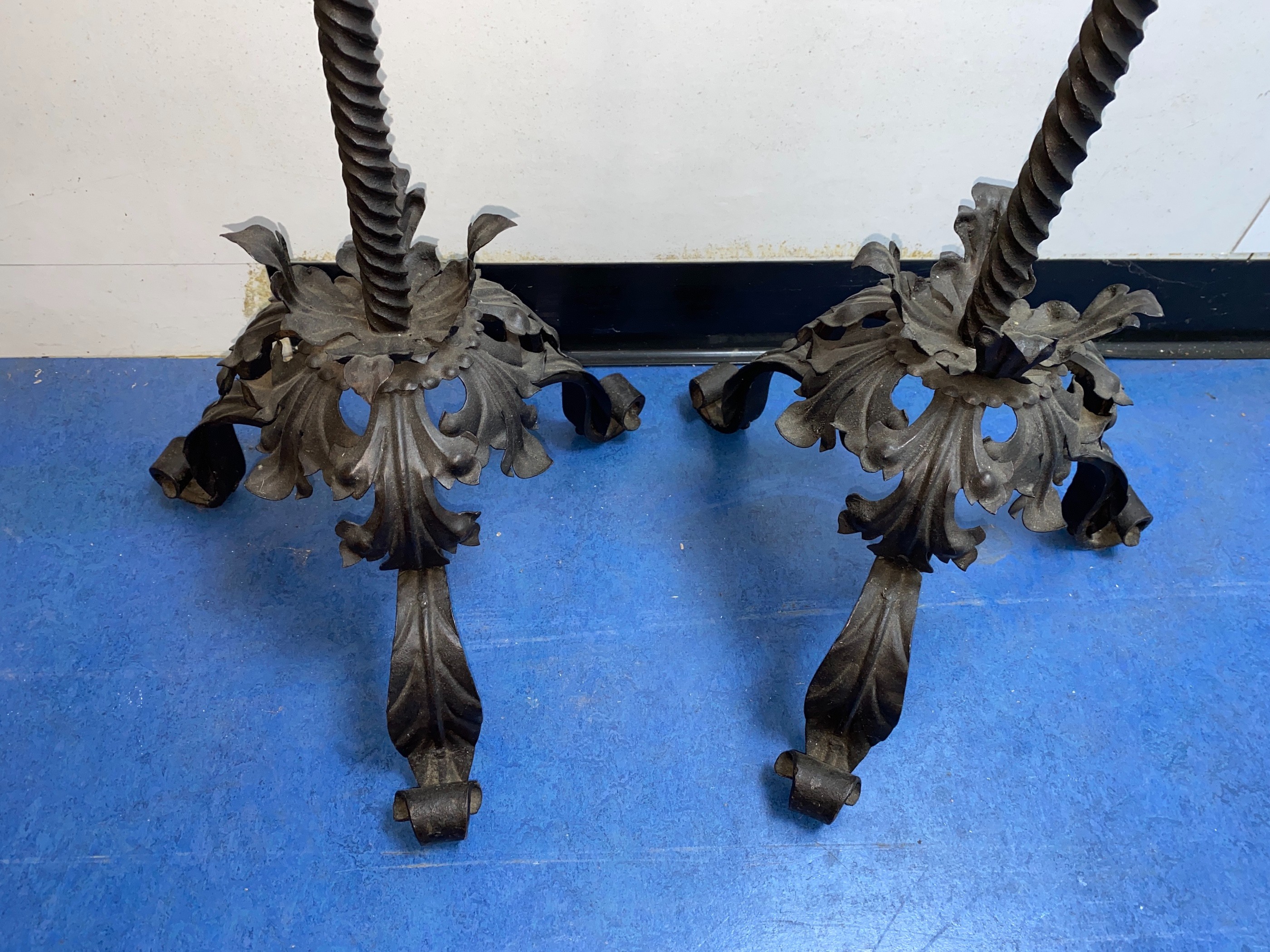 A pair of wrought iron Prickett lamp standard candlesticks, in the 18th century manner, height 157cm. width of base 38cm.